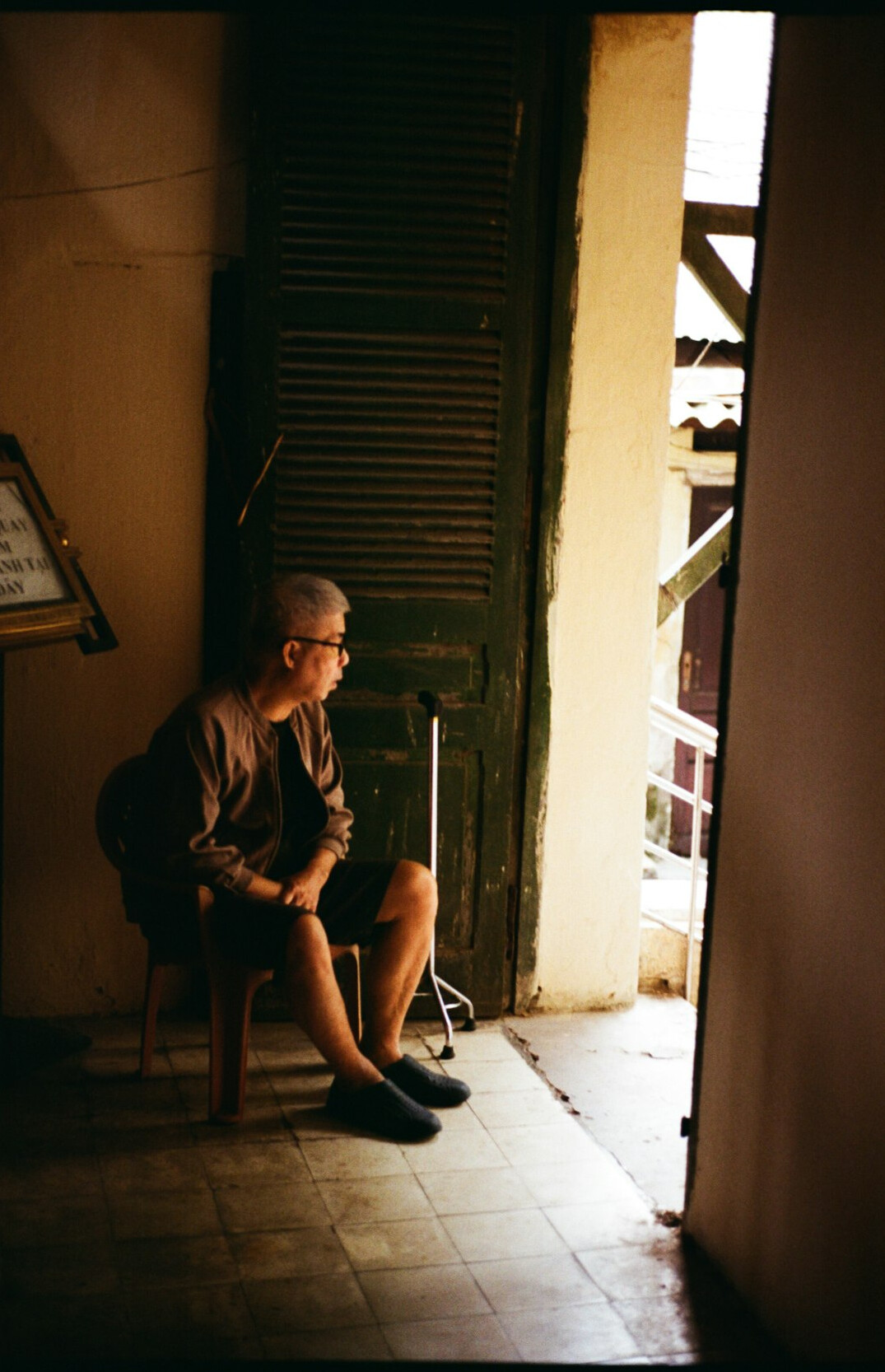 Elderly man standing at his doorway in a Chilean neighborhood