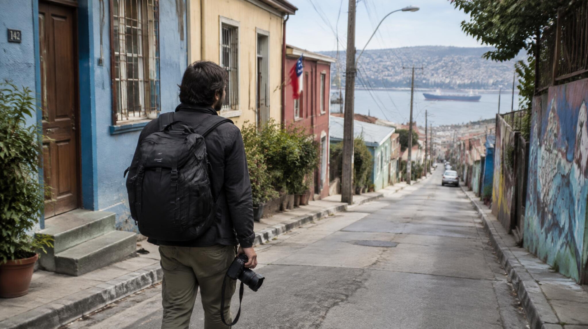 Photographer walking through a city neighborhood street with a camera