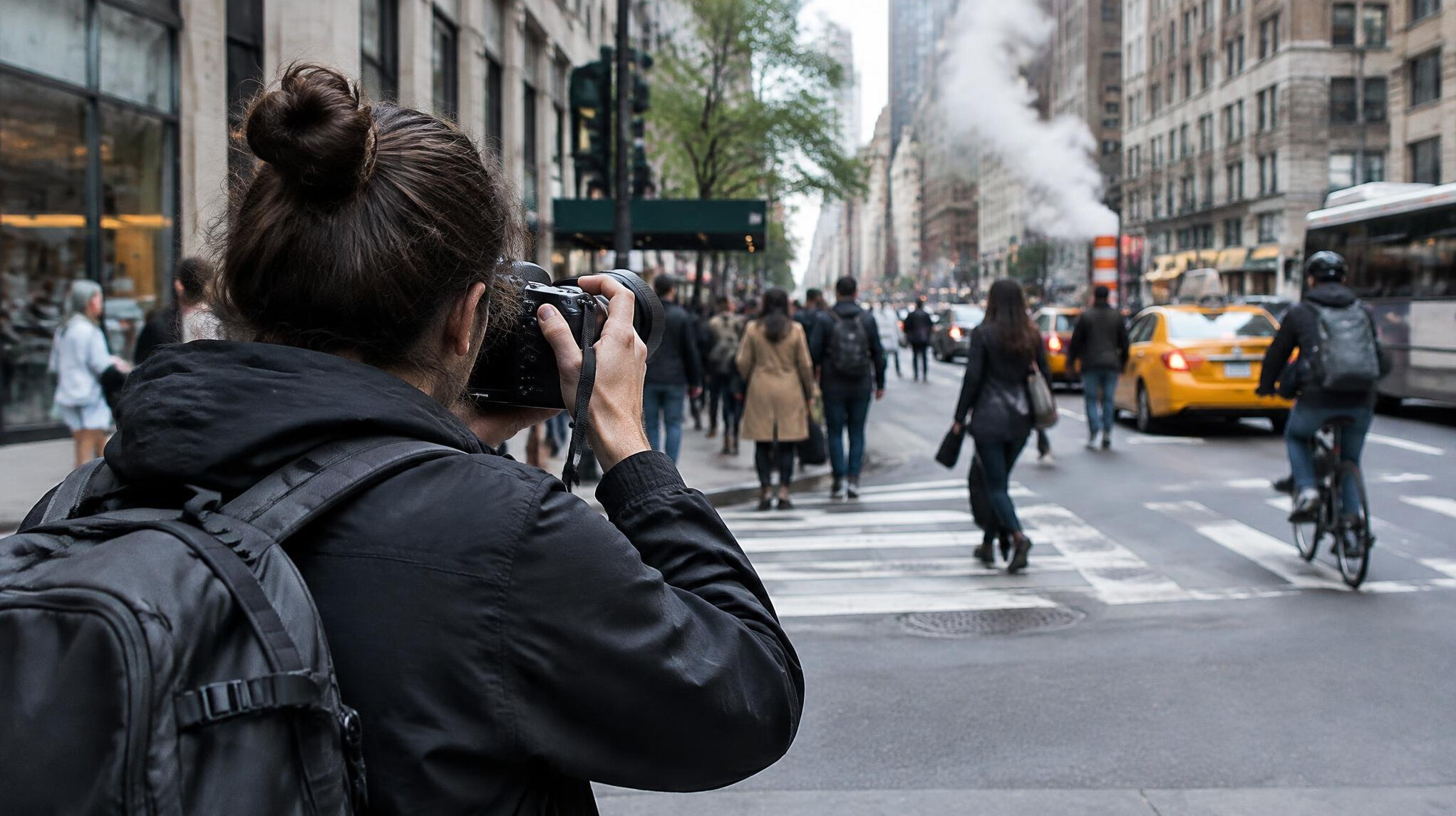 Photographer photographing a street scene from behind