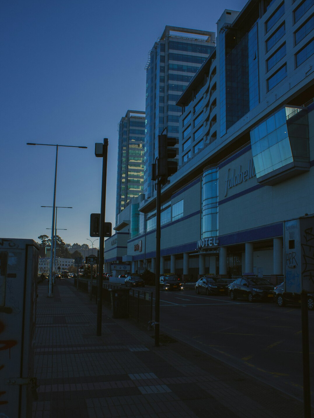 People walking on a busy modern city street in Chile at dusk